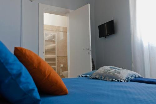 a bedroom with a blue bed with a television on the wall at B&B Mamma Carolina in Sanarica