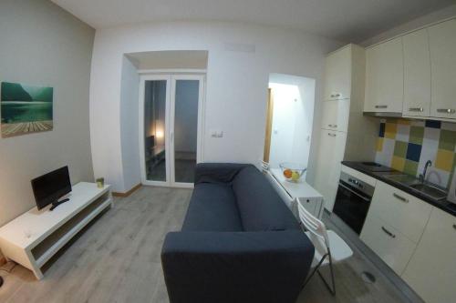 een woonkamer met een blauwe bank en een keuken bij Coimbra Holiday Residence in Coimbra