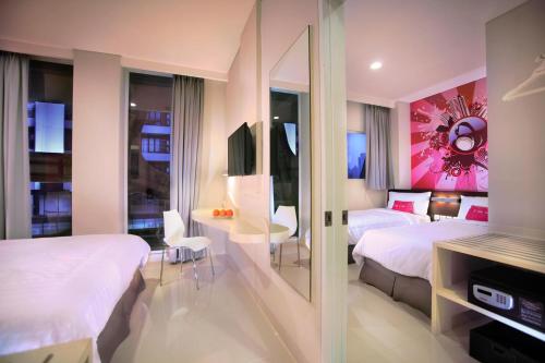 a hotel room with two beds and a table at favehotel Gatot Subroto Jakarta in Jakarta