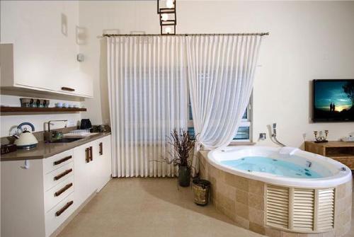 a bathroom with a bath tub in a kitchen at Villar in Rosh Pinna