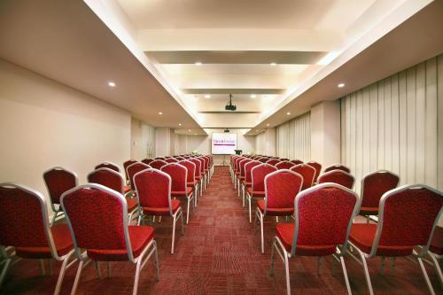 an empty room with red chairs and a screen at favehotel Gatot Subroto Jakarta in Jakarta