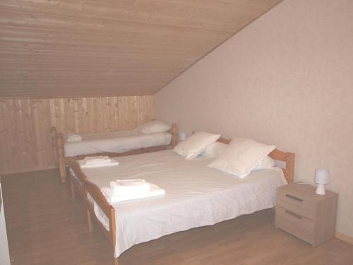 a bedroom with two beds and a night stand at LE CHEMINARD in Feugarolles