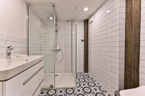 une salle de bain avec douche et lavabo dans l'établissement Apartment Nebovidy II - Air Conditioning - Historic City Center, à Prague