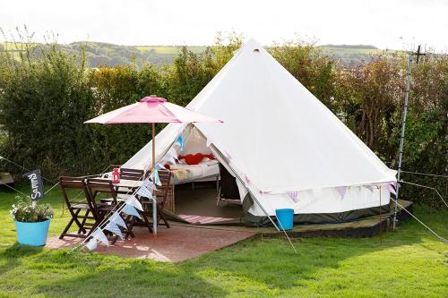 a tent with a table and an umbrella at Whitecliff Bay Holiday Park in Bembridge