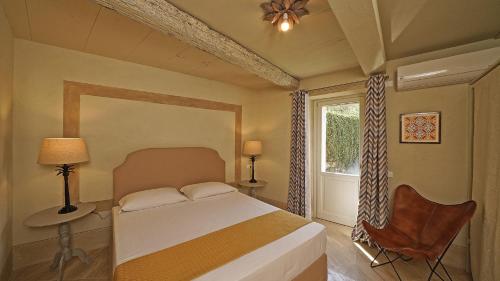 a bedroom with a bed and a window and a chair at Dogoli Country Apartments in Bardolino