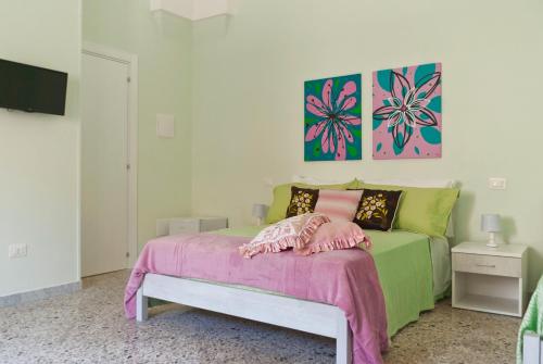 a bedroom with a bed with pink and green at B&B Mamma Carolina in Sanarica