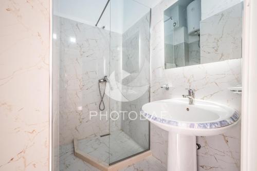 a bathroom with a shower and a sink at Inn Hotel in Durrës