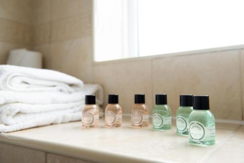 three bottles of soap sitting on a sink in a bathroom at Hotel Ambassadeur in St. Clements