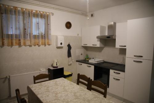 una cucina con mobili bianchi e un tavolo con sedie di Apartments Sustic a Kaštela (Castelli)