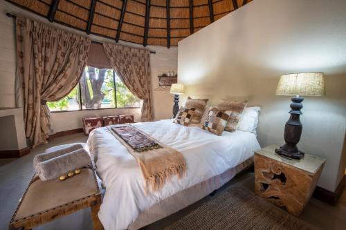 a bedroom with a large bed and a window at Malilule Safaris in Hoedspruit