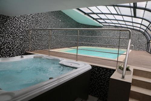 a hot tub in a room with two swimming pools at Hotel Solar do Rebolo in Oliveira do Hospital