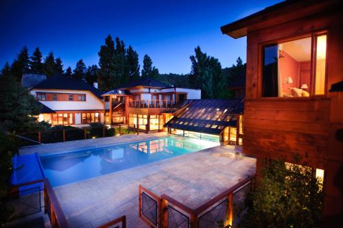 a house with a swimming pool at night at Hostería Antares Patagonia by Visionnaire in San Martín de los Andes