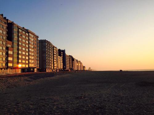 una fila di edifici sulla spiaggia al tramonto di Appartement met prachtig zicht op zee a Ostenda