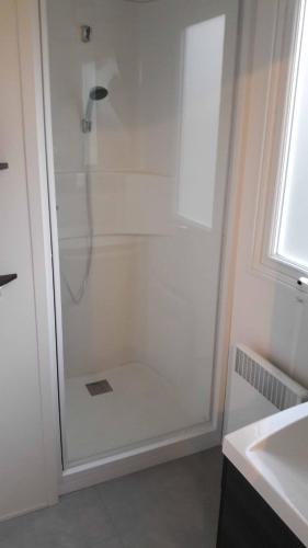 une douche avec une porte vitrée dans une salle de bain dans l'établissement Mobilhome 756 CLIMATISE le Bois Dormant 4 etoiles, à Saint-Jean-de-Monts