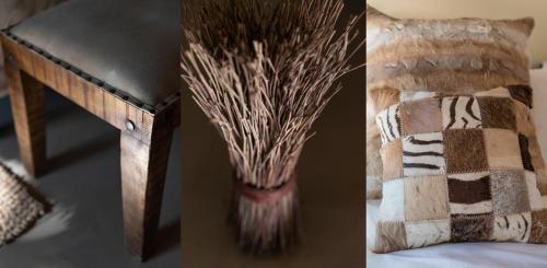 a vase with grass in it next to a table at Malilule Safaris in Hoedspruit