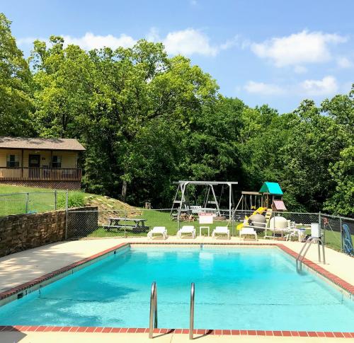 a swimming pool with a playground in the background at Mill Creek Resort on Table Rock Lake in Lampe
