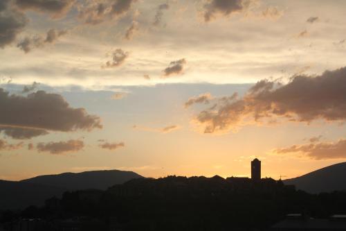 een zonsondergang met een klokkentoren op een heuvel bij MontePerdido in Aínsa