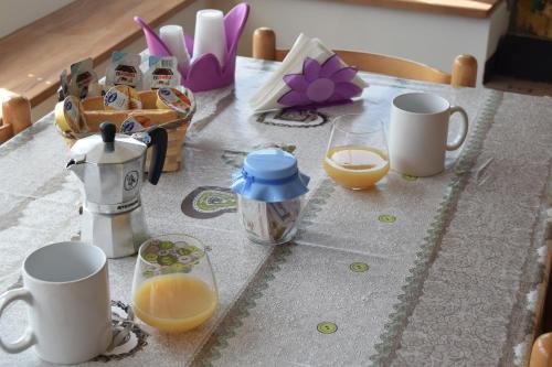 B&B La terrazza في مونتالبانو إليكونا: طاولة مع أكواب وأكواب من عصير البرتقال