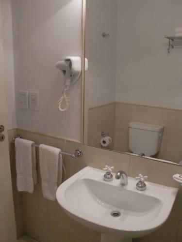 a bathroom with a white sink and a mirror at Piccaluga Apartments in Buenos Aires