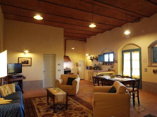 ein Wohnzimmer mit Sofas und einem Tisch sowie eine Küche in der Unterkunft Cortona Resort-Le Terre Dei Cavalieri in Cortona