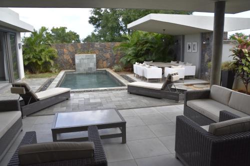 a patio with a pool with chairs and a table at Luxury Villa at Royal Park Sandpiper in La Bergerie