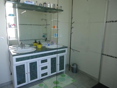ein Badezimmer mit zwei Waschbecken und einer Glasdusche in der Unterkunft Chambres d'hôtes à CUILLÉ in Cuillé