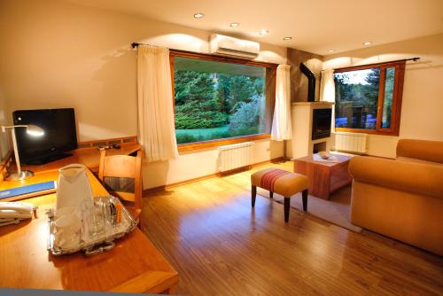 a living room with a couch and a table at Hostería Antares Patagonia by Visionnaire in San Martín de los Andes