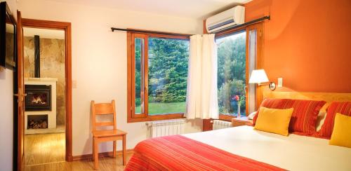 1 dormitorio con cama, ventana y silla en Casa Antares Patagonia en San Martín de los Andes