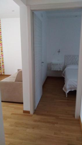 a white bedroom with a bed and a wooden floor at Da Oreste Affittacamere in Fara San Martino