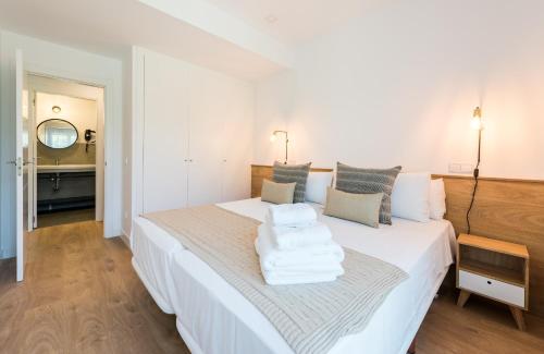 a bedroom with a white bed with towels on it at Plaza de España Skyline in Madrid