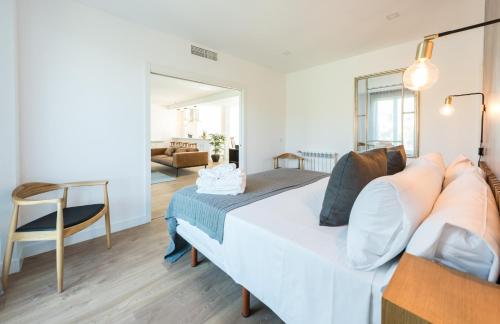 a bedroom with a white bed and a chair at Plaza de España Skyline in Madrid