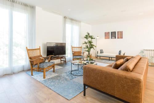 a living room with a couch and chairs and a tv at Plaza de España Skyline in Madrid