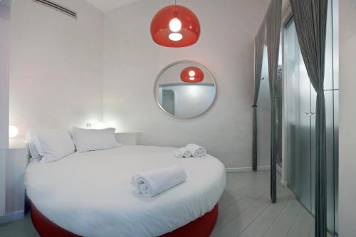 a bedroom with a large white bed and a mirror at Wrh Trastevere in Rome