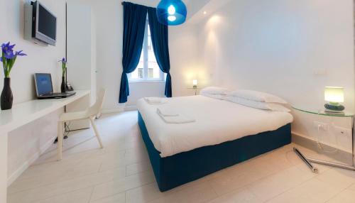 a bedroom with a bed with a desk and a window at Wrh Trastevere in Rome