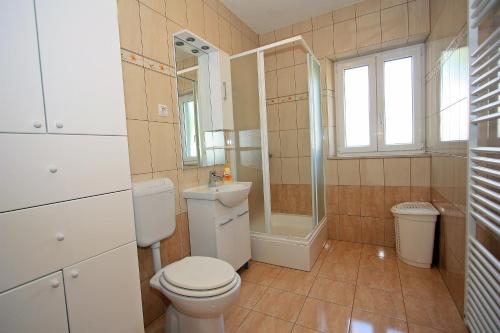 e bagno con servizi igienici, lavandino e doccia. di Apartment Igor a Supetar (San Pietro di Brazza)