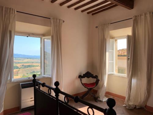 a bedroom with a bed and two windows at Casa Cerboneschi in Casale Marittimo