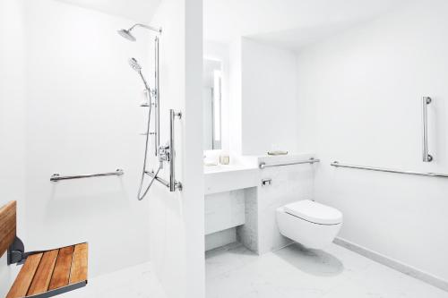 a white bathroom with a toilet and a shower at Park Terrace Hotel in New York