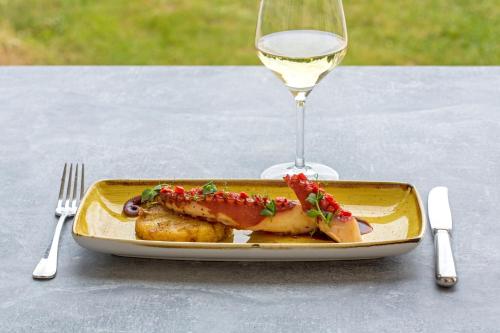 a plate of food on a table with a glass of wine at Mercure Chantilly Resort & Conventions in Chantilly