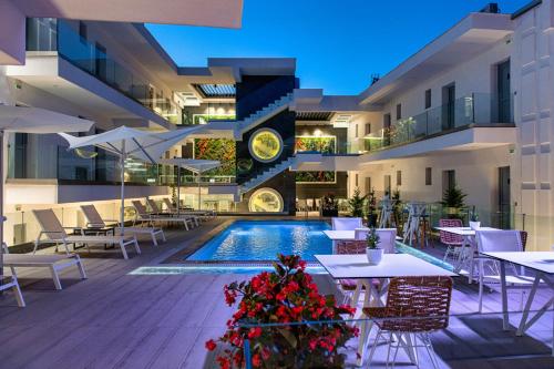 un hotel con piscina, mesas y sillas en Sunway Hotel en Kallithea Halkidikis