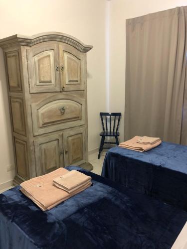 a bedroom with two beds and a wooden dresser at Hostel Borba Gato in Sao Paulo