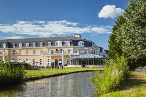 a large building next to a river at Mercure Chantilly Resort & Conventions in Chantilly