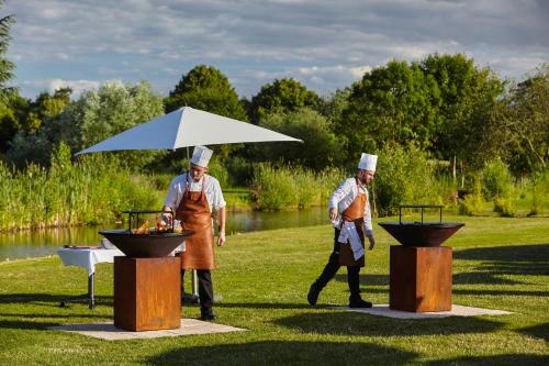 two people in chefsuits walking around a grill at Mercure Chantilly Resort & Conventions in Chantilly
