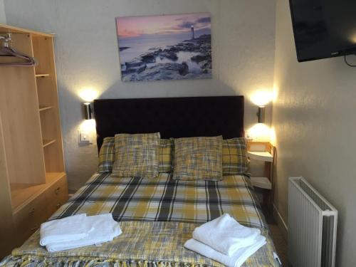 a bedroom with a bed with two towels on it at Kirkstall Guest House in Blackpool