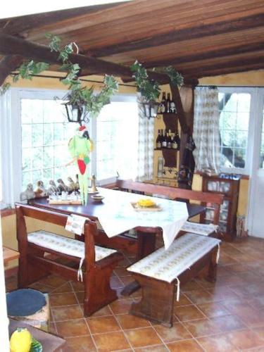a kitchen with a table and benches and windows at La Maison Galu' in Itri