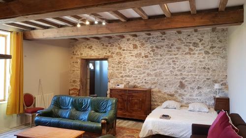 ein Wohnzimmer mit einem Bett und einer Couch in der Unterkunft Le Beugnon in La Pommeraie-sur-Sèvre