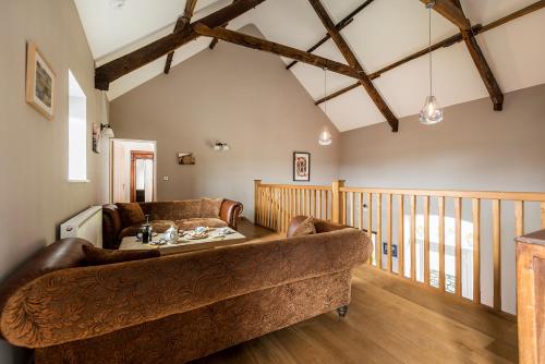 un soggiorno con divano e pavimenti in legno di Kidwelly Farm Cottage a Kidwelly