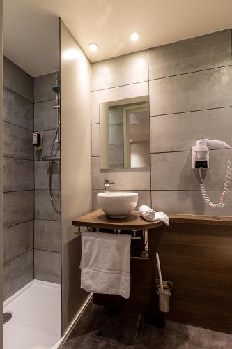 une salle de bain avec un lavabo et une douche dans l'établissement Hotel Terminus Saint-Charles, à Marseille