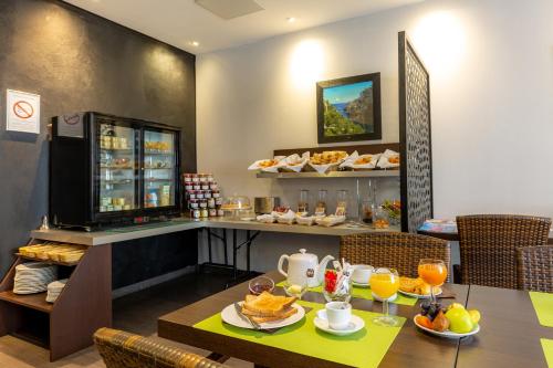 a restaurant with a table with food on it at Hotel Terminus Saint-Charles in Marseille