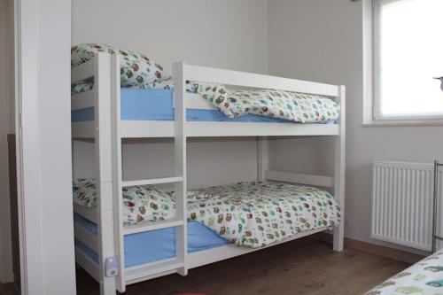 two bunk beds in a room with a bed at Villa Appartement Amaryllis in Nieuwpoort
