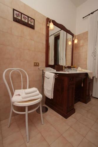 a bathroom with a sink and a chair and a mirror at La Maison Galu' in Itri